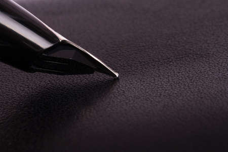 Close up view of seamless black leather texture with fountain pen.の写真素材