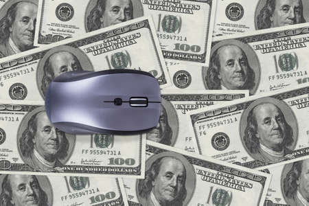 Finance concept, one hundred dollar banknotes under computer mouse.の写真素材