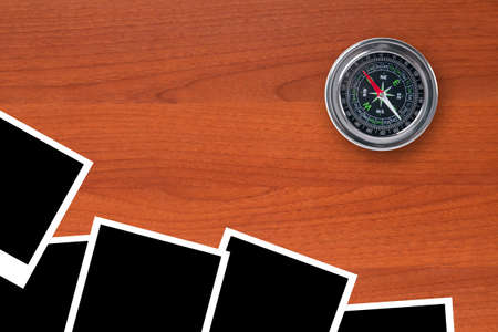 Blank, black picture frames with compass on wooden table.の写真素材