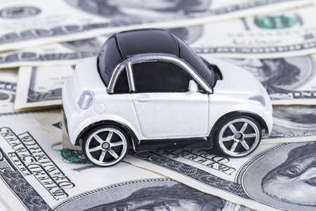 One hundred dollar banknotes with small, toy car.の写真素材