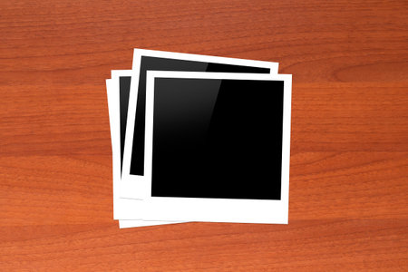 Blank, black picture frames with copy space on wooden table.
