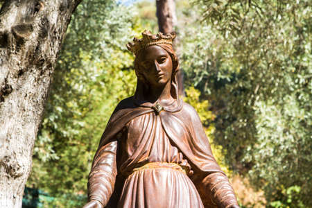 Front view of bronze statue of Virgin Mary in natural place.の写真素材