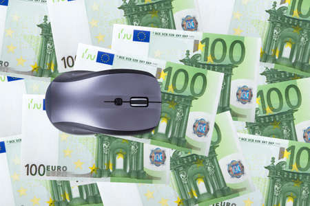 Finance concept, one hundred euro banknotes under computer mouse.の写真素材
