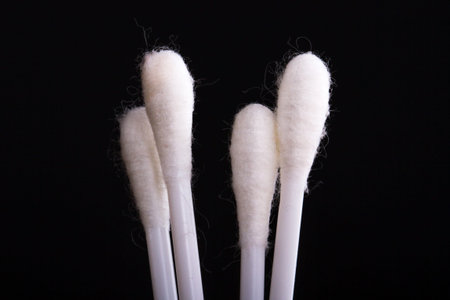 White cotton swabs on black background.