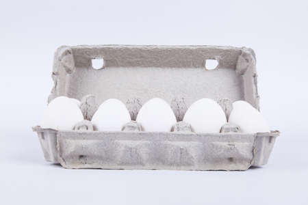 White eggs in carton with front view, isolated on white background.の写真素材