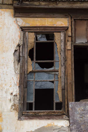 Close up detailed front view of broken window of abandoned old building.の写真素材
