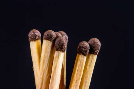 Close up detailed front view of matches, on black background.の写真素材