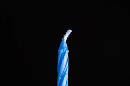 Close up front view of blue birthday cake candle on black background.の写真素材