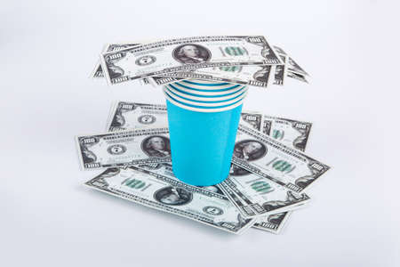 Close up top view of blue paper glasses with banknotes of one hundred dollar on and under, isolated on white background.の写真素材