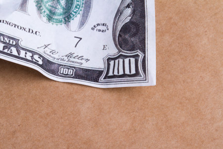 Close up detailed top view of crumpled one hundred dollar bannotes, on brown background.の写真素材