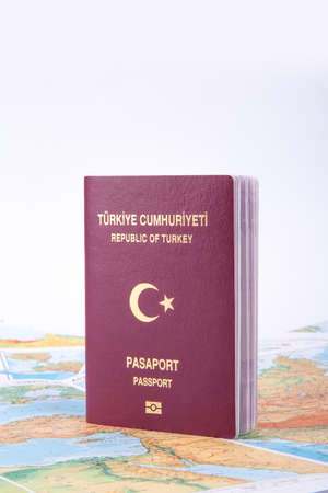 Close up detailed view of a Turkish passport standing on a world map, isolated on white background.の写真素材