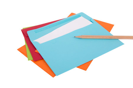 Close up top view of a pencil lying on empty envelope, isolated on white background.