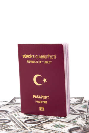 Close up front view of a Turkish passport on one hundred dollar banknotes, isolated on white background.の写真素材