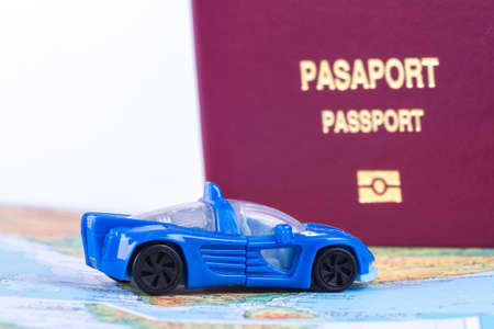 Close up detailed view of a passport on a world map with a toy car.の写真素材