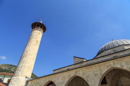 Side view of the walls and minaret of historical Habibi Neccar Mosque in Antakya, on blue sky background.の写真素材
