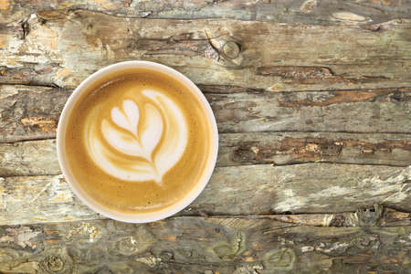 Top view of latte art coffee with heart figure, on wooden background.の写真素材