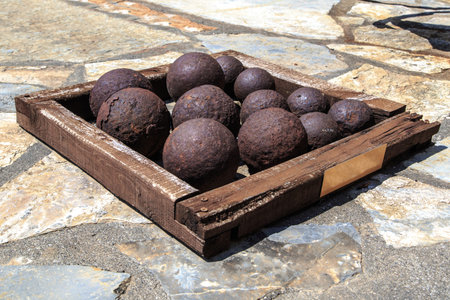Many of historical old cannon balls, heap of iron rusty balls.