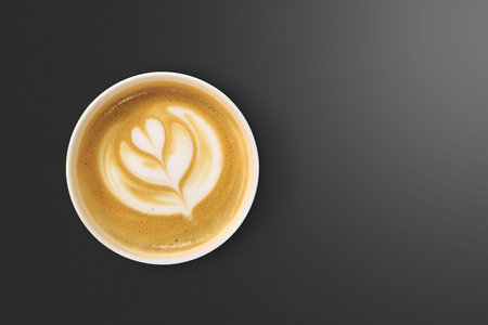 Top view of latte art coffee with heart figure, on black background.の写真素材