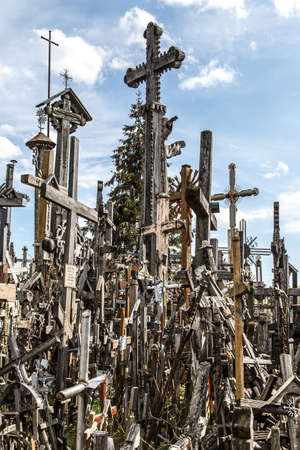 SIAULIAI, LITHUANIA - MAY 1, 2015 : View of hill of crosses with over four hundred thousand crosses and crucifix, which is thought  tradition of putting a cross traces to 1800s, on cloudy sky background.のeditorial素材