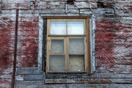 Close up view of yellow wooden window of the old red or brown wooden building.の写真素材