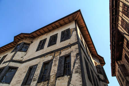 Bottom view of historical old and abandoned wooden and stone house of Yoruk Village in Safranbolu, Karabuk, on blue sky background.の写真素材