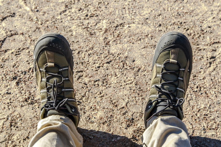 Top view of man foot with trekking shoes, on ground floor background.の写真素材
