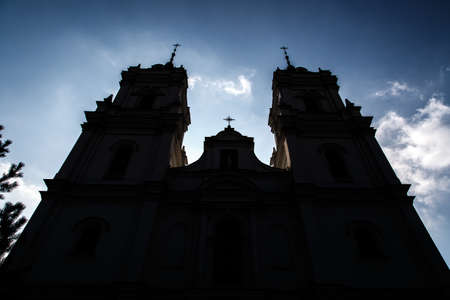 Bottom front silhouette view of Roman Catholic Cathedral in Ludza, Latvia, on cloudy blue sky background.の写真素材