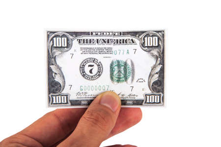 Close up view of one hundred dollar banknote, holding on hand, isolated on white background.