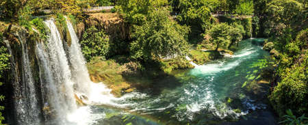 View of Duden Waterfall in Antalya, flowing from high, with green trees and plants around.の写真素材
