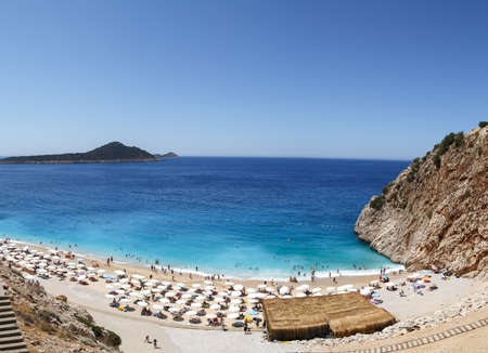 ANTALYA, TURKEY - JULY 19, 2015 : Top view of famous canyon junction beach of Antalya, Kaputas Beach with its turquoise water color, view of people swimming and sunbathing on bright blue sky background.のeditorial素材