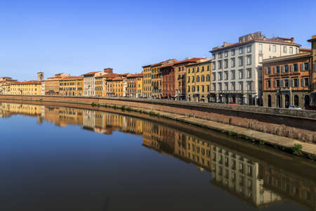 PISA, ITALY - SEPTEMBER 21, 2015 : View of historical buildings along the river in Pisa, Italy on bright blue sky background.のeditorial素材