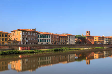 PISA, ITALY - SEPTEMBER 21, 2015 : View of historical buildings along the river in Pisa, Italy on bright blue sky background.のeditorial素材
