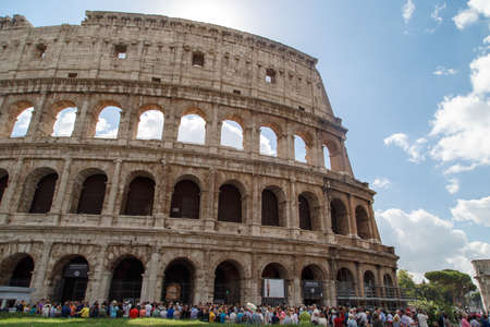 ROME, ITALY - SEPTEMBER 24, 2015 : View of ancient amphitheatre of Colosseum built by Vespasian and Titus in Rome with people around, on cloudy blue sky background.のeditorial素材