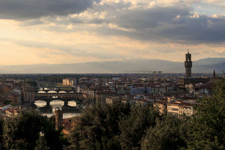 Top view of Florence city with arno river bridges and historical buildings, on cloudy sunrise or sunset sky background.のeditorial素材