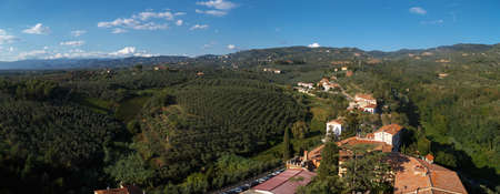 Panoramic top view of Vinci Village around meadow area from Conti Guidi Castle in Italy, under bright blue sky background.のeditorial素材
