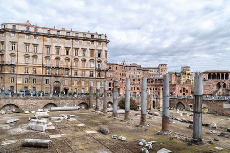 ROME, ITALY - SEPTEMBER 26, 2016 : View of an ancient Roman Forum with columns and ruins around in Rome, with tourists around, on cloudy sky background.のeditorial素材