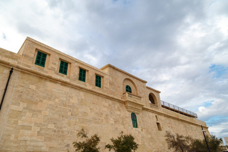 View of National War Museum in Valletta, Malta with high yellow stone walls, on cloudy sky background.のeditorial素材