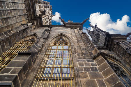 Close up detailed view of historical gothic St. Vitus Cathedral in old town of Prague, found in 1344, on cloudy blue sky background.のeditorial素材