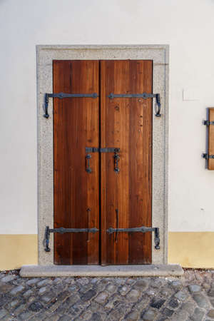 Close up detailed view of old wooden door on a white wall.の写真素材