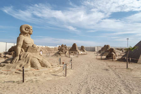 ANTALYA, TURKEY - APRIL 23, 2016 : View of big sand sculpture of mythological characters made in Lara Beach, Antalya for sandland project, on cloudy blue sky background.のeditorial素材