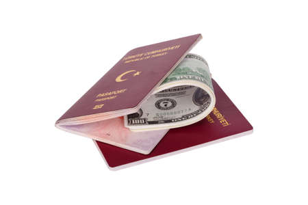 Finance concept, stack of hundred dollar money banknotes in passport with the text Republic of Turkey in Turkish, isolated on white background.の写真素材