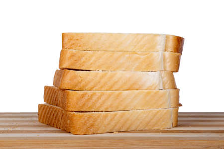 Side view of slices of toast bread on breadboard, isolated on white background.の写真素材