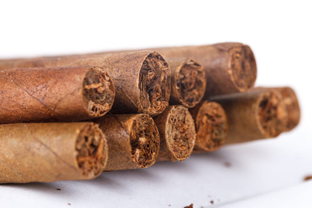 Chocolate cigars in row on white background.