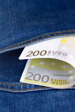 Close up detailed view of Euro banknotes on jeans pocket, two hundred euros in pants pocket.