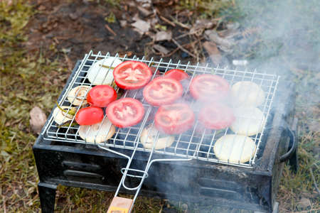 Close up view of barbecue grill with various vegetables on backyard.の写真素材