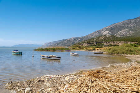 AYDIN, TURKEY - MAY 1, 2016 : Seascape view of sandy beaches with small sailing boats around, on blue sky background.の写真素材