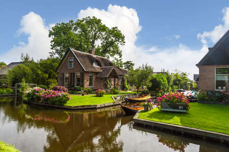 OVERIJSSEL, NETHERLANDS - JULY 4, 2016 : View of small sailboats in canals around thatched roof houses. Giethoorn is very popular village.のeditorial素材