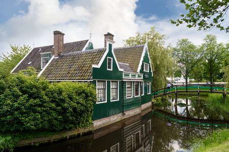 ZAANDAM, NETHERLANDS - JULY 4, 2016 : View of traditional small village houses in farm on cloudy sky. Zaanse Schans is popular with windmills.のeditorial素材