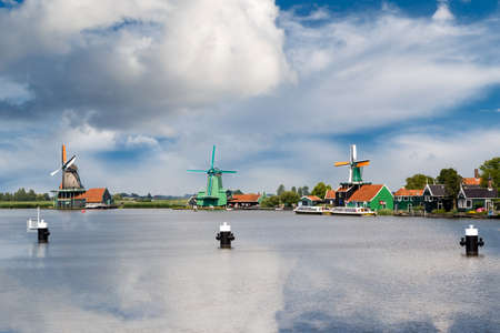 View of famous windmills in Zaanse Schans village in Zaandam on cloudy sky background.のeditorial素材