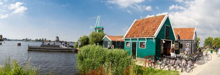 ZAANDAM, NETHERLANDS - JULY 4, 2016 : View of traditional small village houses in farm on cloudy sky. Zaanse Schans is popular with windmills.のeditorial素材